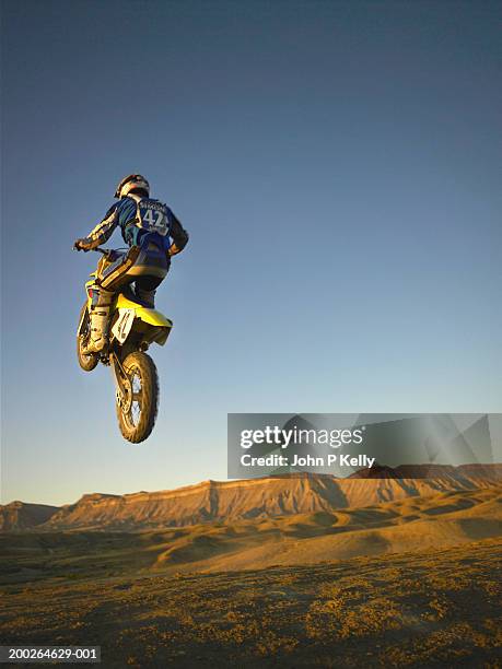 motocross racer in mid air, rear view - dirt bike stock pictures, royalty-free photos & images