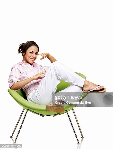 woman sitting on chair, smiling, portrait - relaxing white background stock-fotos und bilder