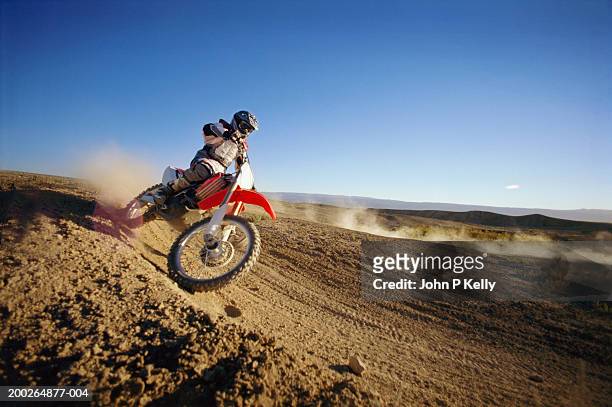 motocross driver on dirt road, side view - motocross stock photos et images de collection