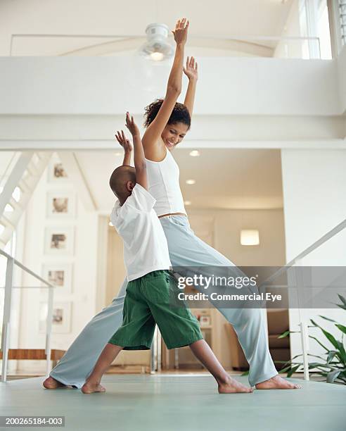 mother and son (5-7) practicing yoga at home, side view - family yoga photos et images de collection