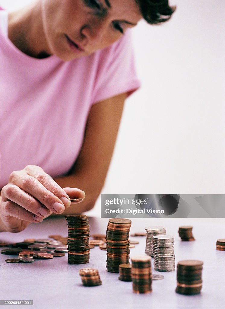 Woman at table stacking coins