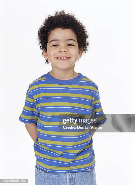 boy (4-6) standing with hands behind back, smiling, portrait - mani dietro la schiena foto e immagini stock