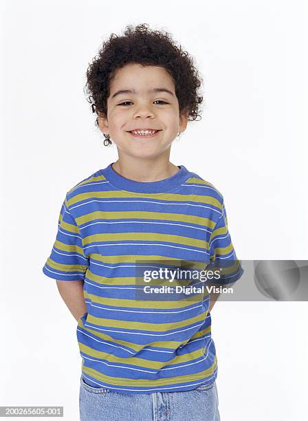 boy (4-6) standing with hands behind back, smiling, portrait - hands behind back stockfoto's en -beelden