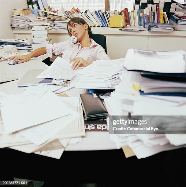 woman sitting in messy office using phone - chaos büro stock pictures, royalty-free photos & images
