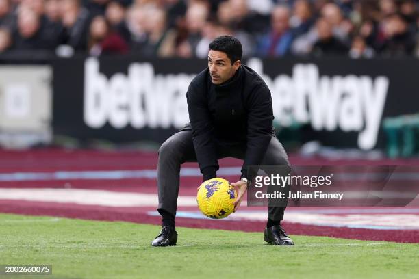 Mikel Arteta, Manager of Arsenal, looks on with the Nike Flight Aerowsculpt Hi-Vis Premier League match ball during the Premier League match between...