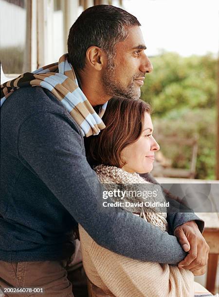 man embracing woman outdoors, side view - mature indian couple stock-fotos und bilder