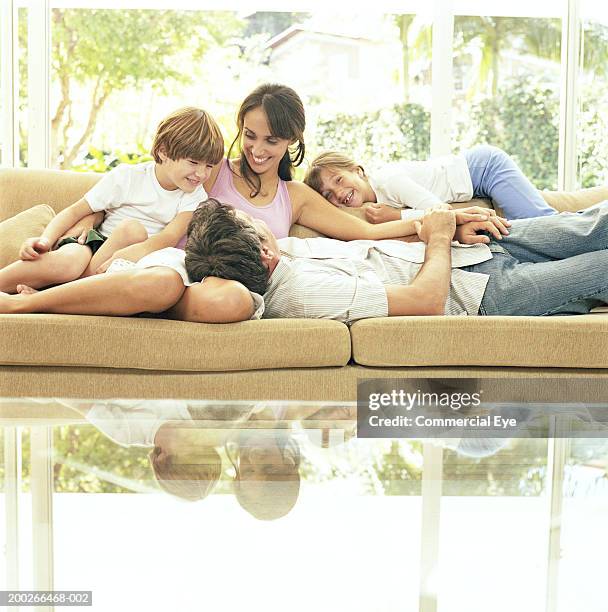 family laughing on couch - lying on back girl on the sofa stock pictures, royalty-free photos & images