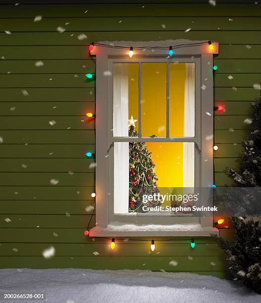 girl (4-6) looking out of window, snow falling - christmas window stock pictures, royalty-free photos & images