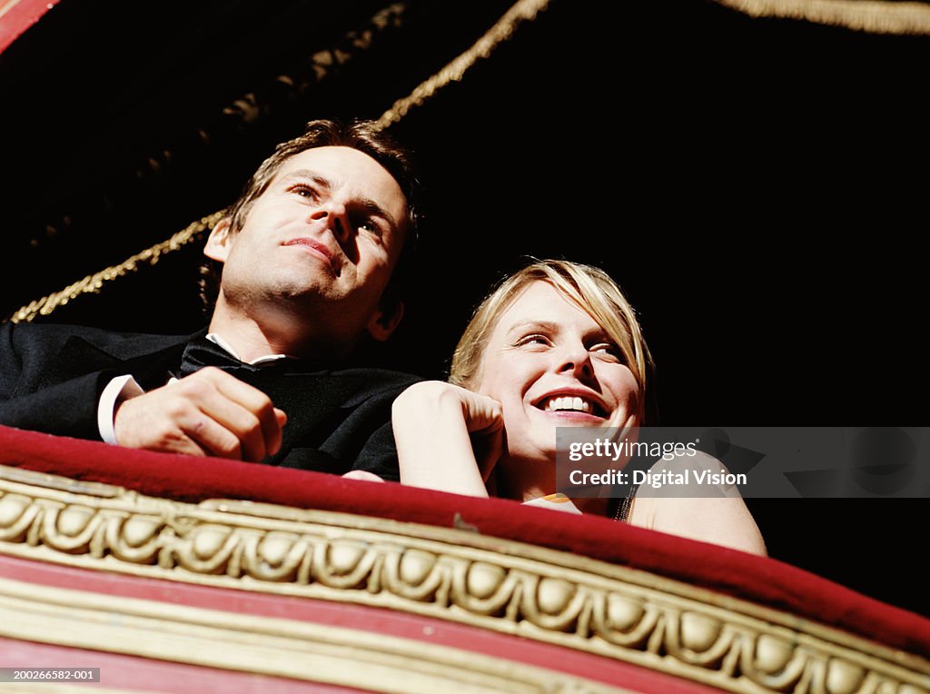 Couple in theatre box, smiling, low angle view