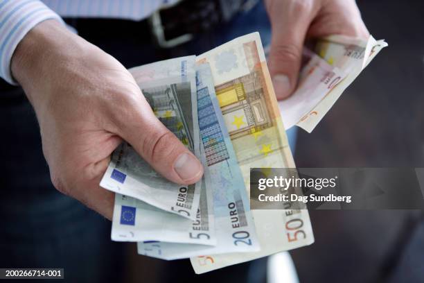 man holding euro currency: various denomination notes - ユーロ ストックフォトと画像