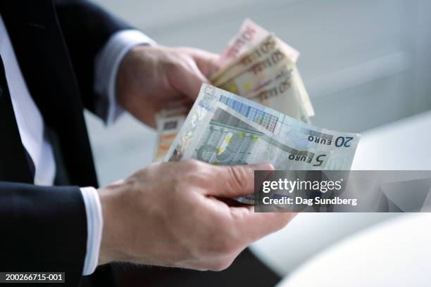 man holding euro currency: various denomination notes - nota de euro da união europeia imagens e fotografias de stock