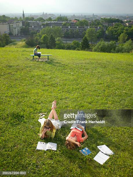 young women lying in park with books, elevated view - krakow park stock pictures, royalty-free photos & images