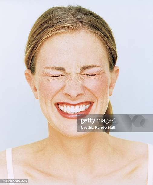 young woman smiling, eyes closed, close-up - portrait grimace stock pictures, royalty-free photos & images