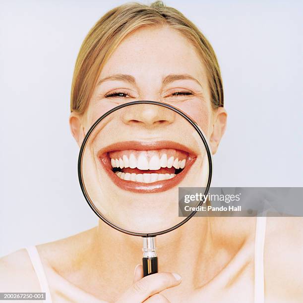 woman holding magnifying glass in front of mouth, smiling, portrait - big toothy smile stock pictures, royalty-free photos & images