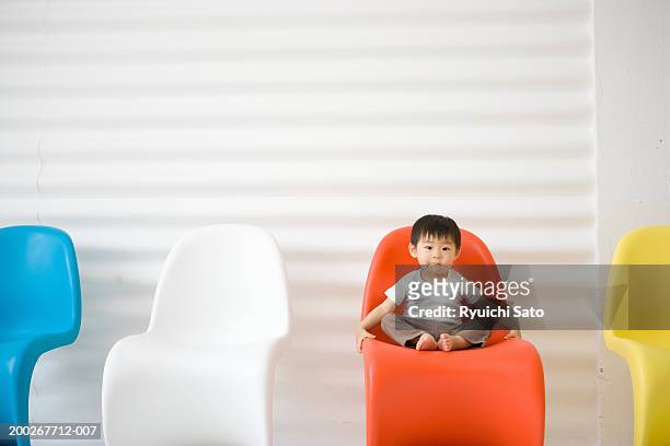 baby boy (18-21 months) sitting in row of chairs, portrait - one baby boy only fotografías e imágenes de stock