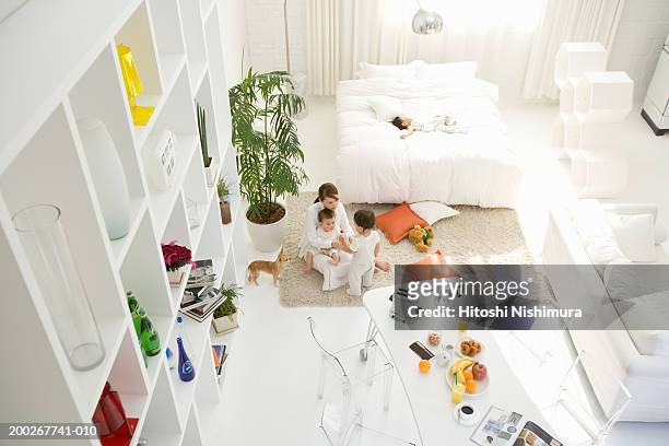 mother and three children (6-21 months) in living room, elevated view - baby hund innenaufnahme stock-fotos und bilder
