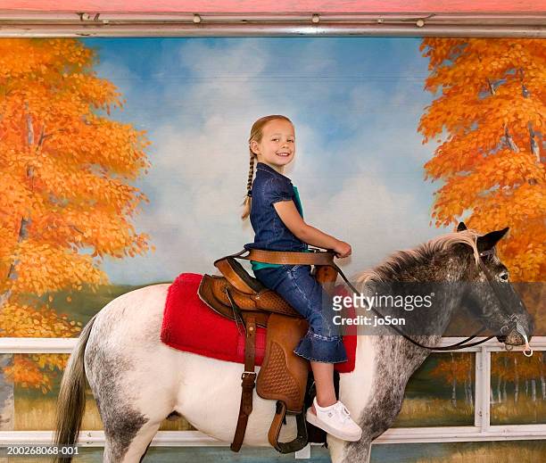girl (4-6) sitting on pony smiling, portrait - pony stock pictures, royalty-free photos & images