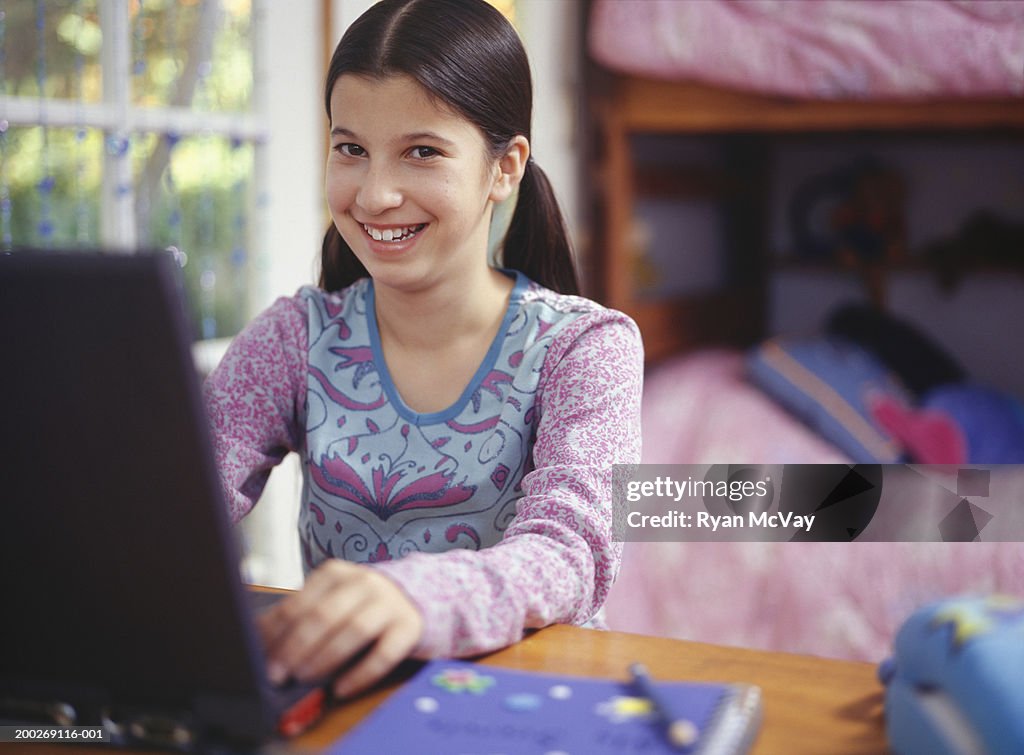 Girl (13-14) using laptop, portrait