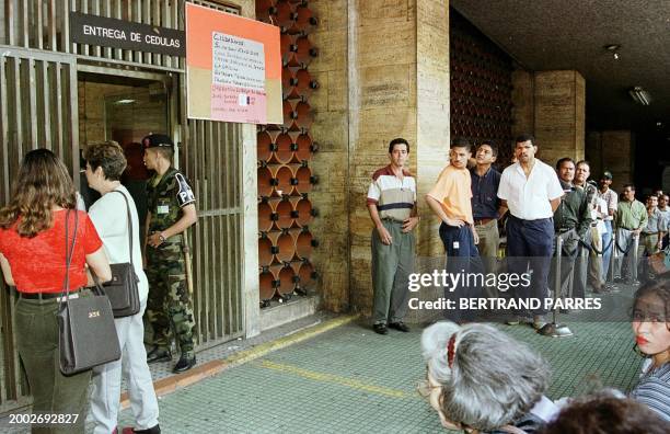 Some hundreds of people wait outside a voter registration office in Caracas 23 July to get the proper papers to vote in the 25 July constitutional...