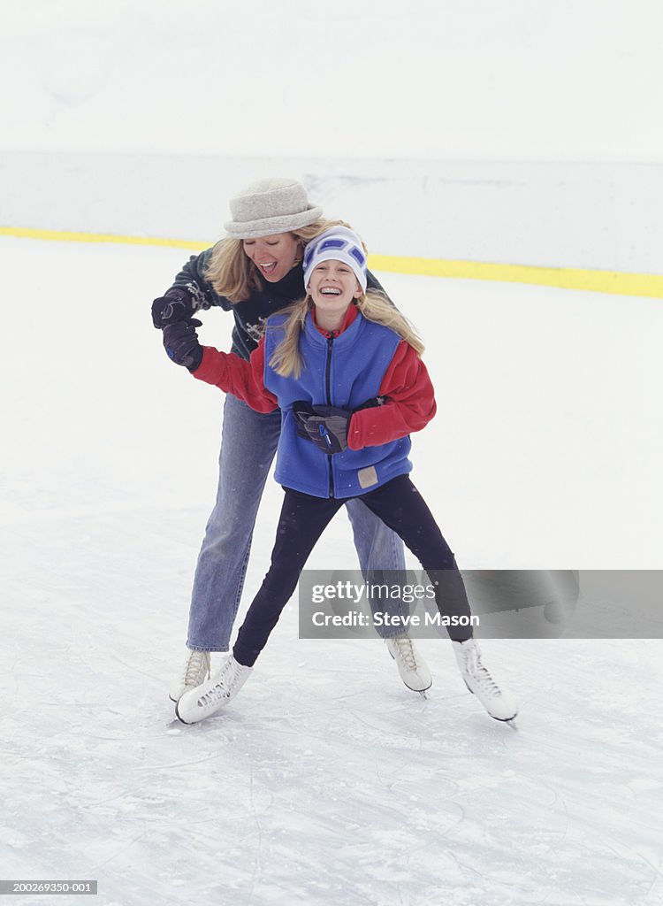 Mother and daughter (13-14) ice skating