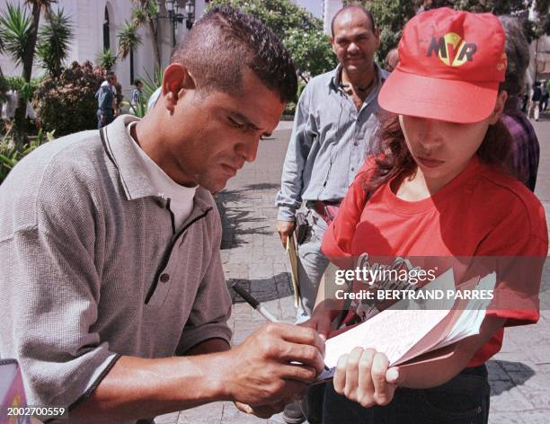 Man signs a petition for a referendum for the constitution in Caracas. Un hombre firma una lista de respaldo al Presidente Hugo Chavez Frias en la...