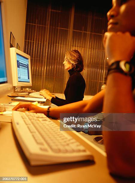 women using computers at internet cafe, side view - casual low view desk cafe stock pictures, royalty-free photos & images