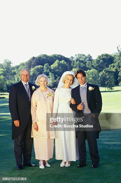 bride and groom with mother and father posing at outdoor wedding, portrait - mother and daughter smoking stock-fotos und bilder