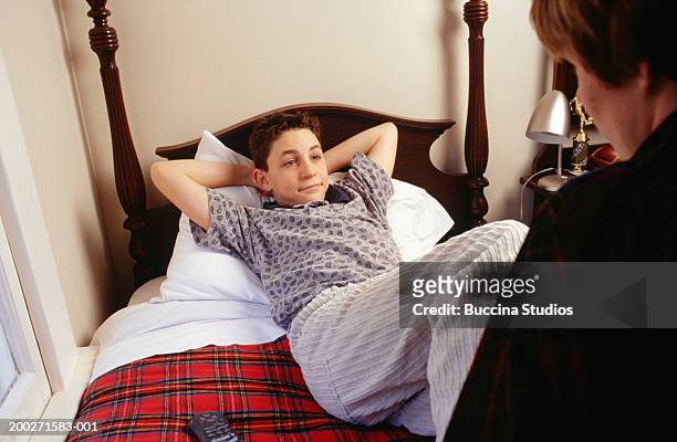 mother talking to teenage son (16-17) lying on bed - hands behind head stock pictures, royalty-free photos & images