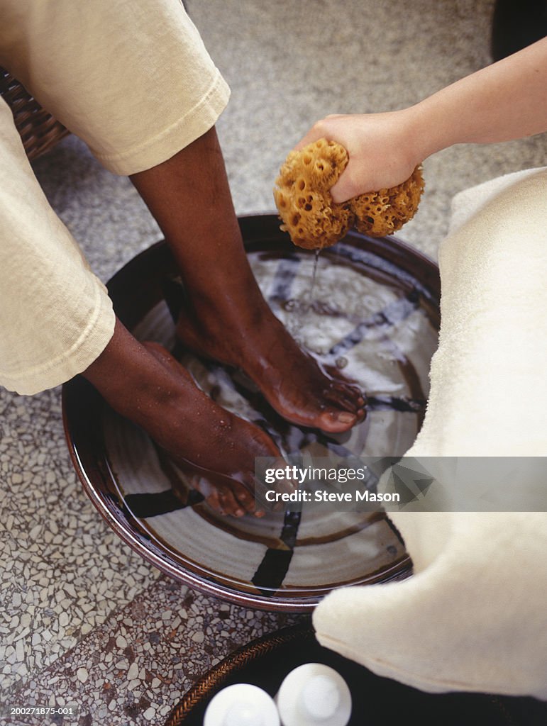 Women having feet washed in beauty parlour, low section, elevated view