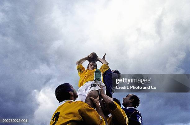 rugby lineout jumper being supported by team-mates, low angle view - sport and team photos et images de collection