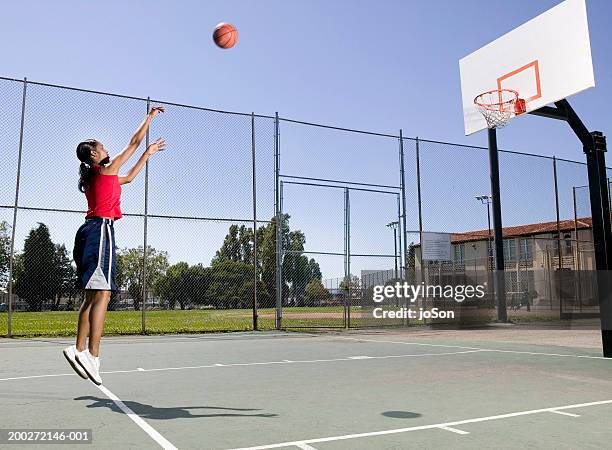 young woman shooting basketball - wurf oder sprungdisziplin damen stock-fotos und bilder