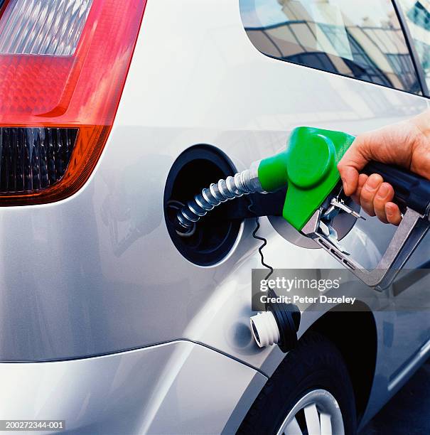 man filling up car with petrol, close-up - only mature men fotografías e imágenes de stock