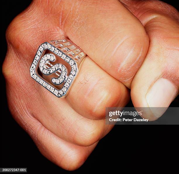 man clenching fist, 'dollar' sign ring on finger, close-up - bling bling stock pictures, royalty-free photos & images