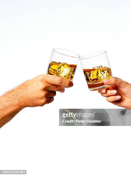 man and woman toasting drinks, close-up - whiskey stock pictures, royalty-free photos & images
