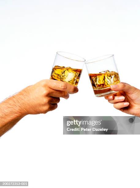 man and woman toasting drinks, close-up - whisky stock pictures, royalty-free photos & images