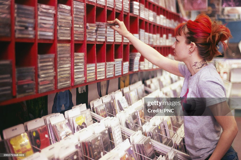 Young woman selecting CD in record store, side view