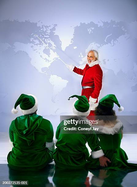 'santa' showing three 'elves' world map (digital composite) - the jolly green giant is back stock pictures, royalty-free photos & images