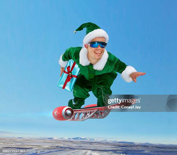 'elf' flying on 'jet board', holding present (digital composite) - little people stock pictures, royalty-free photos & images