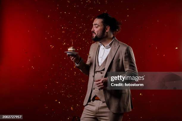 making the birthday wish while confetti are exploding in the background - exploding cake stock pictures, royalty-free photos & images