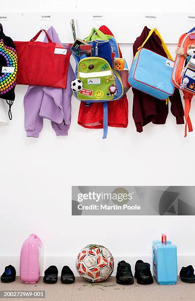 bags and coats hanging in children's cloakroom - cartella scolastica foto e immagini stock