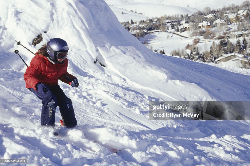 Girl (12-13) skiing down ski slope in mountains
