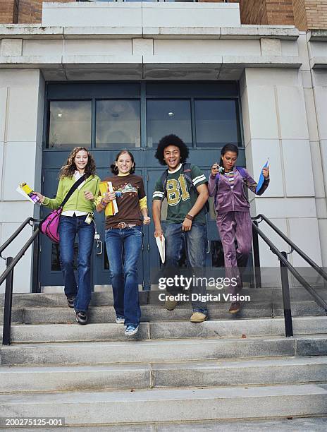 three teenage girls and teenage boy (13-16) walking down school steps, smiling - leaving school imagens e fotografias de stock