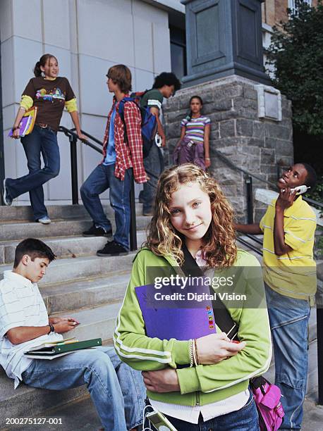 teenage girl (13-15) standing by school steps, smiling, portrait - boy tracksuit stock pictures, royalty-free photos & images