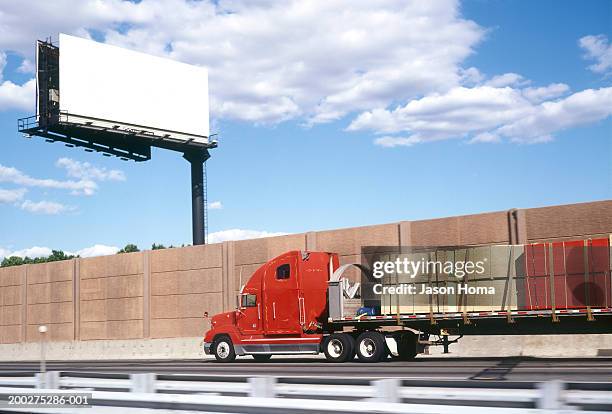 truck passing billboard, low angle view - billboard truck stock-fotos und bilder