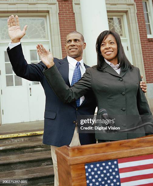 businessman and businesswoman waving from podium outside building - black politician stock pictures, royalty-free photos & images