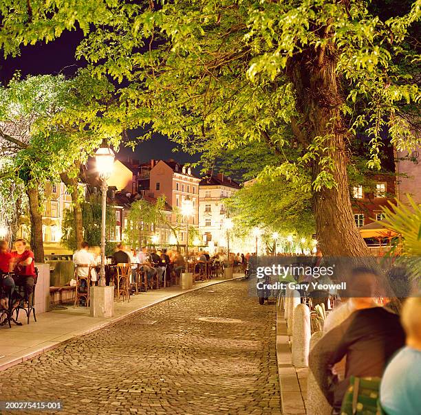 slovenia, ljubljana, cafes and bars along cobbled street at night - eslovenia fotografías e imágenes de stock