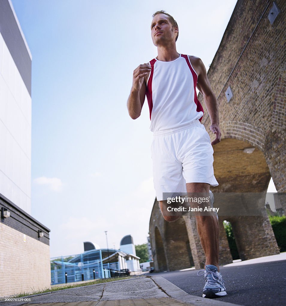 Man running in street, low angle view