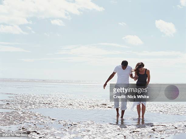 couple walking through shallow pool on beach - ankle deep in water bildbanksfoton och bilder