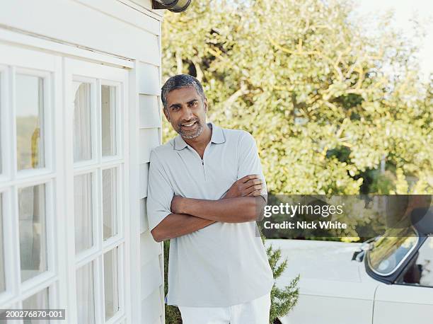 man standing outdoors leaning against house, smiling, portrait - weatherboard stock pictures, royalty-free photos & images