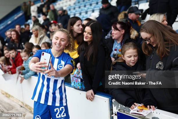 Katie Robinson of Brighton & Hove Albion poses for a photo with fans at full-time following the teams victory in the Adobe Women's FA Cup Fifth Round...